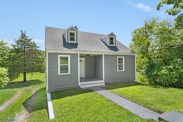 cape cod home featuring a front yard