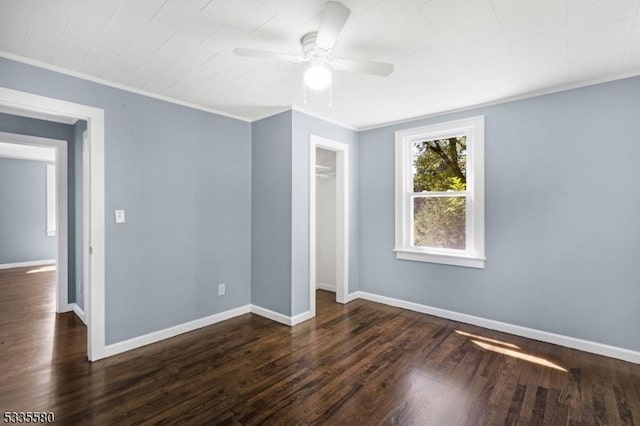 unfurnished bedroom featuring crown molding, ceiling fan, dark hardwood / wood-style floors, and a closet