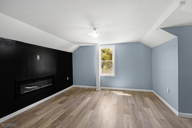 additional living space featuring lofted ceiling and light wood-type flooring