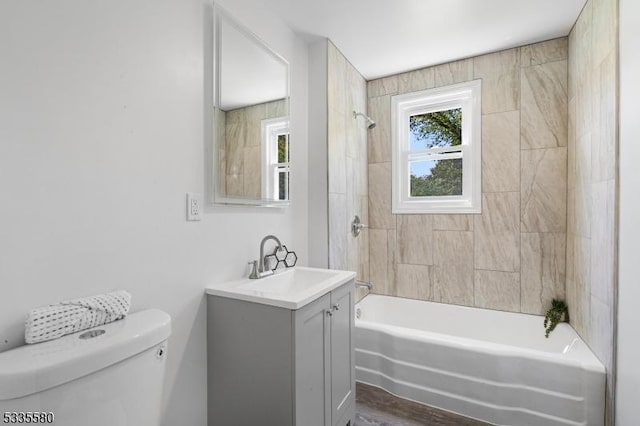 full bathroom with vanity, tiled shower / bath combo, and toilet