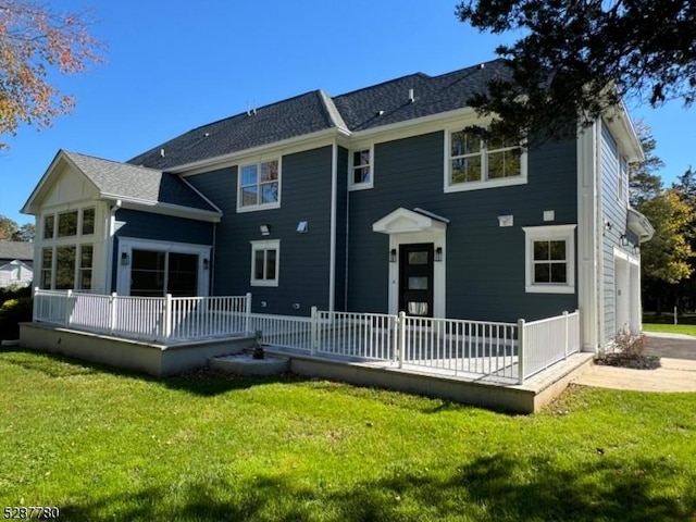 back of house with a garage and a lawn