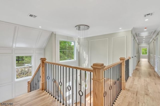 hallway featuring ornamental molding and light hardwood / wood-style floors