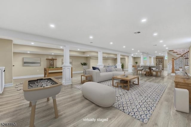 living room with light hardwood / wood-style floors and decorative columns