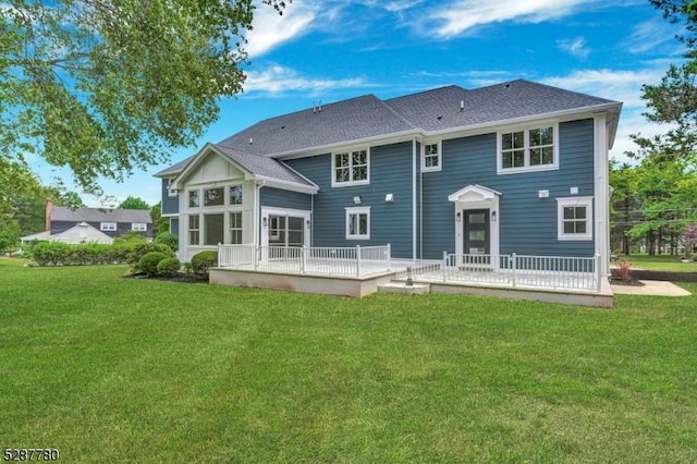 rear view of house featuring a lawn