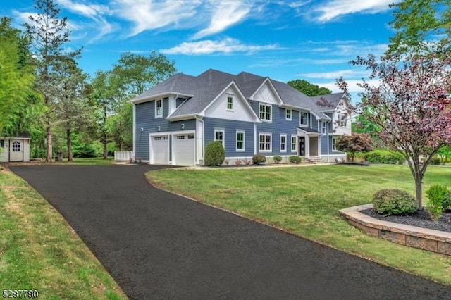 colonial inspired home with a garage and a front lawn