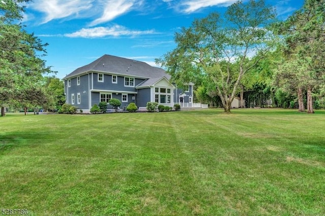 rear view of property featuring a lawn