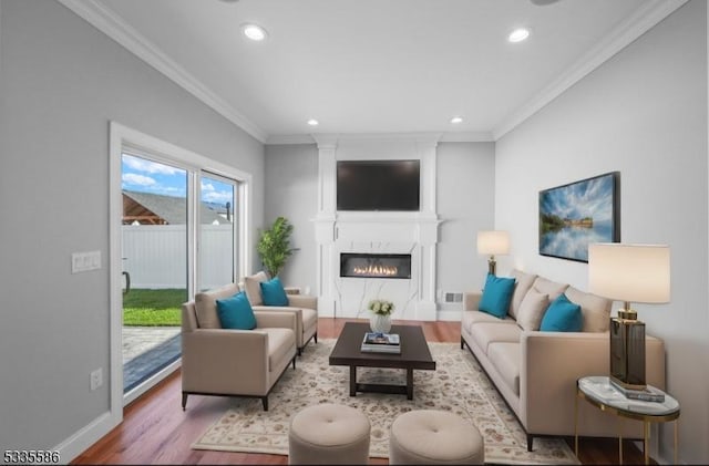 living room with ornamental molding, a fireplace, and light hardwood / wood-style flooring