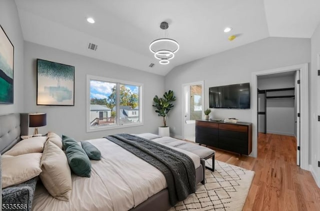 bedroom with lofted ceiling and light wood-type flooring