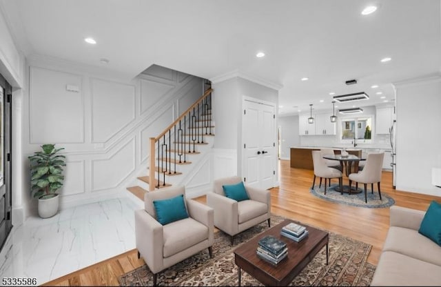 living room featuring crown molding and light hardwood / wood-style flooring