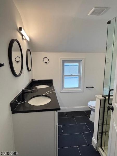 bathroom featuring lofted ceiling, vanity, toilet, and tile patterned flooring