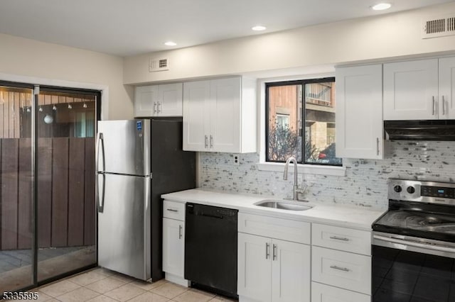 kitchen with light tile patterned flooring, sink, white cabinetry, appliances with stainless steel finishes, and backsplash