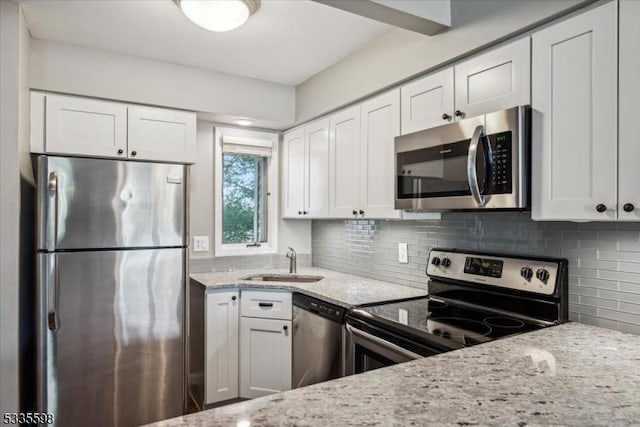 kitchen featuring white cabinetry, stainless steel appliances, sink, and tasteful backsplash