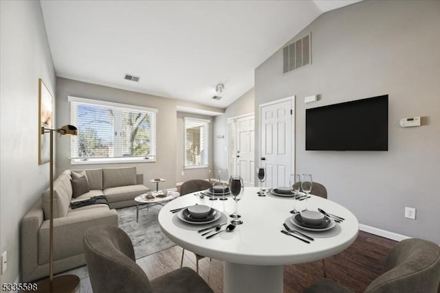 living room featuring a healthy amount of sunlight, vaulted ceiling, and wood-type flooring