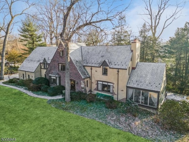 back of property featuring a sunroom and a lawn