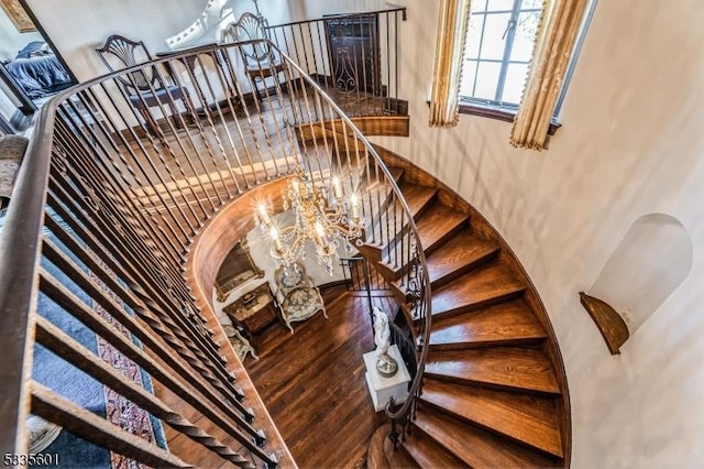 stairway featuring wood-type flooring and a chandelier