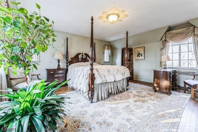 bedroom featuring radiator heating unit and wood-type flooring