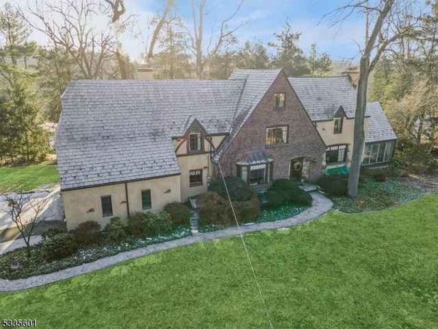 tudor-style house featuring a front yard