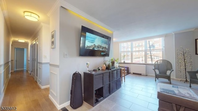 tiled living room with ornamental molding and radiator