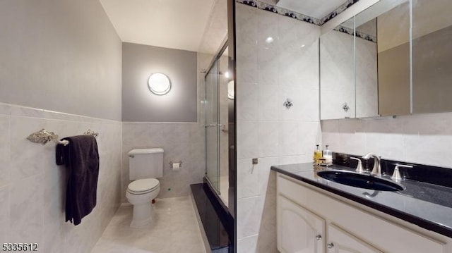 bathroom featuring tile walls, tile patterned flooring, an enclosed shower, vanity, and toilet