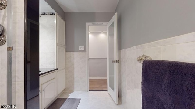 bathroom with tile patterned floors and tile walls