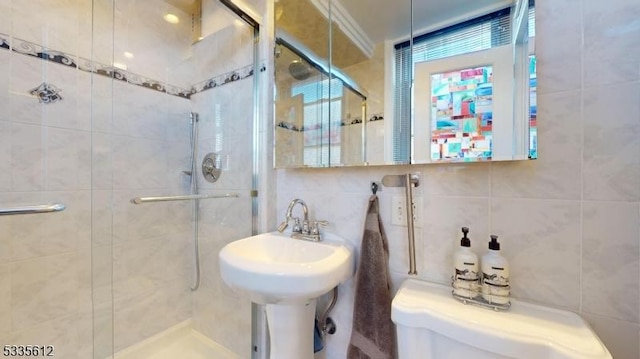 bathroom with toilet, an enclosed shower, sink, tile walls, and backsplash