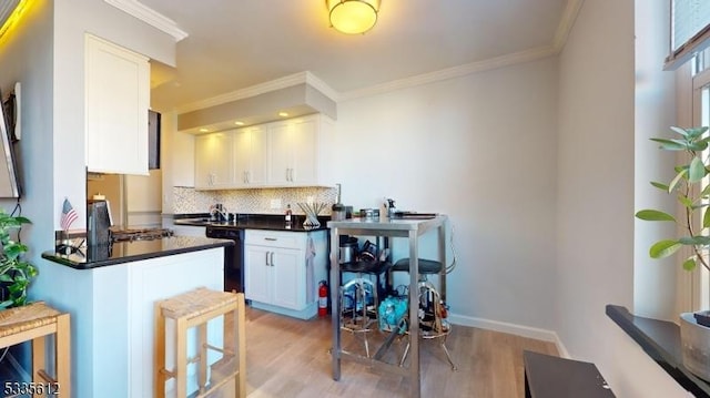 kitchen featuring white cabinetry, backsplash, crown molding, and light hardwood / wood-style flooring