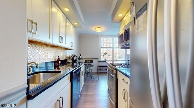 kitchen with sink, crown molding, dark wood-type flooring, backsplash, and stainless steel appliances