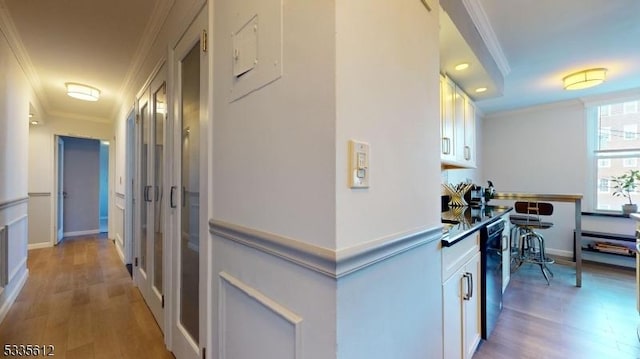 corridor featuring ornamental molding and light wood-type flooring