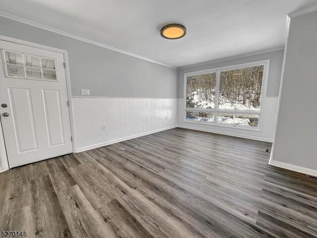 unfurnished dining area with dark hardwood / wood-style flooring and crown molding