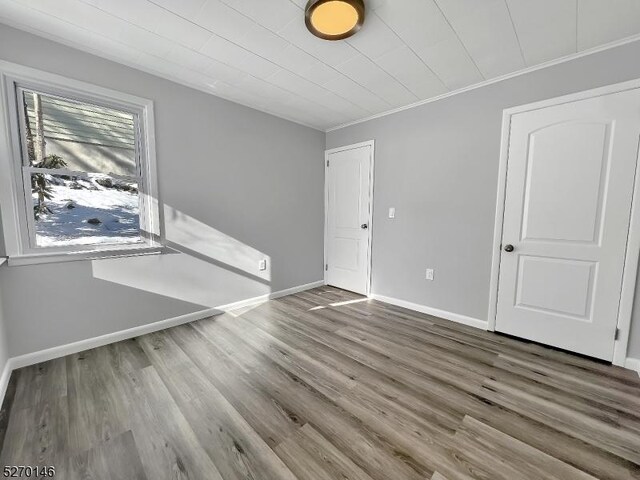 unfurnished room featuring crown molding and hardwood / wood-style flooring