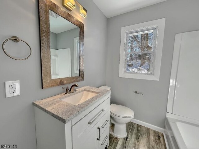 bathroom featuring vanity, hardwood / wood-style floors, and toilet