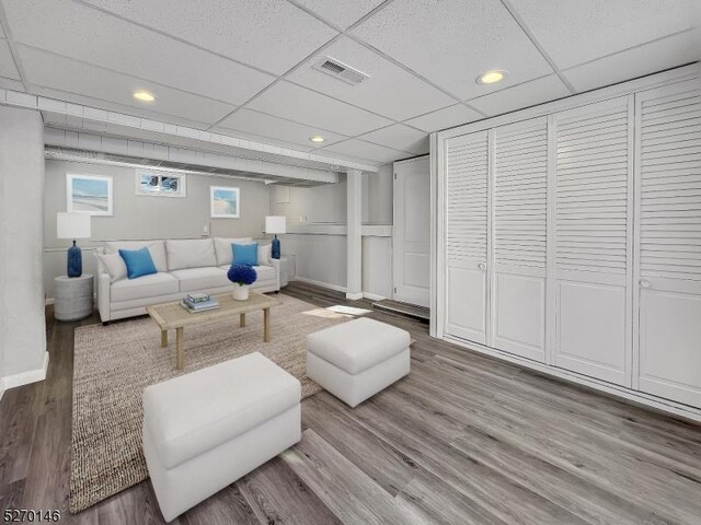 living room with hardwood / wood-style flooring and a drop ceiling