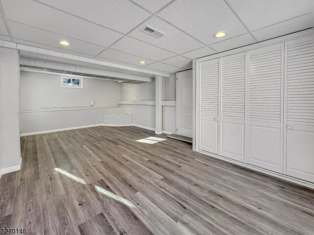 basement with a drop ceiling and light hardwood / wood-style floors