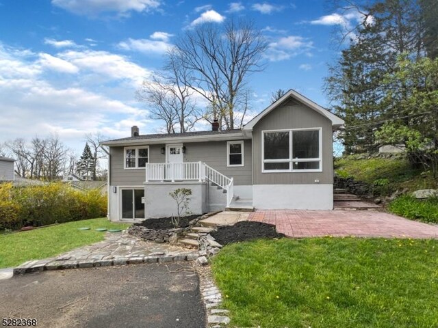 view of front of house with a patio area and a front lawn