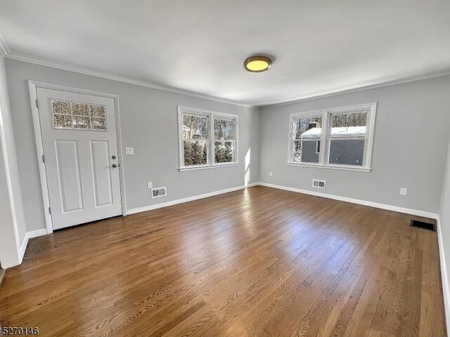 foyer entrance featuring plenty of natural light, ornamental molding, and wood-type flooring