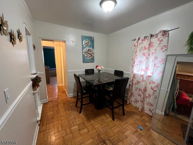 dining space featuring crown molding and parquet flooring