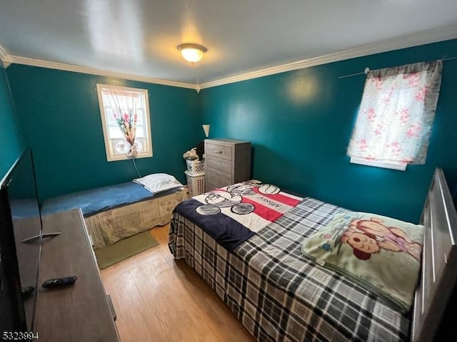 bedroom with ornamental molding and light hardwood / wood-style flooring