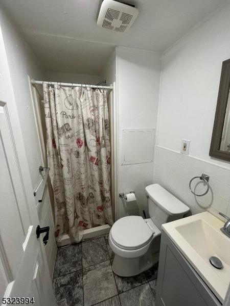 bathroom with vanity, curtained shower, and toilet