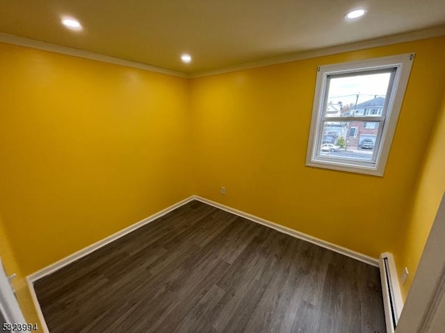 spare room with a baseboard radiator, ornamental molding, and dark hardwood / wood-style floors