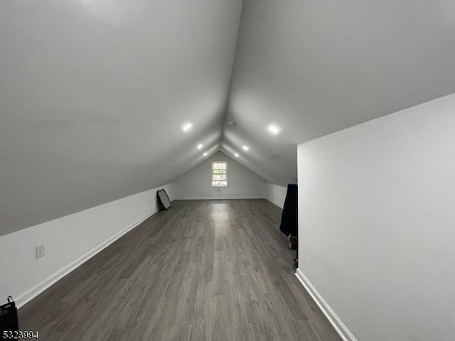 bonus room featuring vaulted ceiling and dark hardwood / wood-style flooring