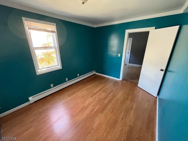 spare room with light hardwood / wood-style flooring, ornamental molding, and baseboard heating