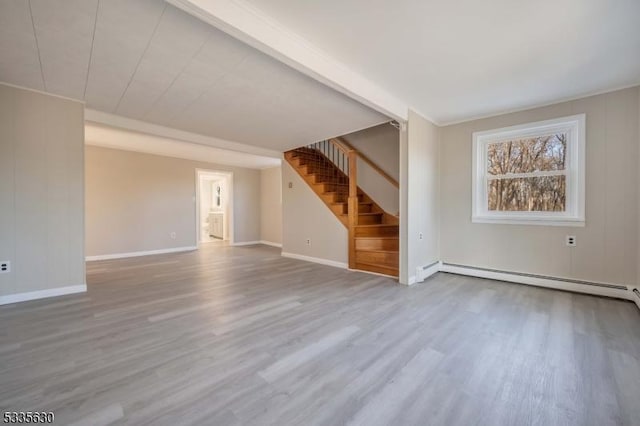 unfurnished living room featuring a baseboard heating unit and light wood-type flooring