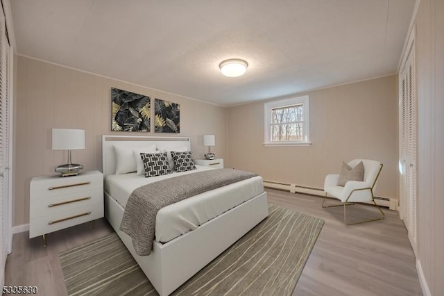 bedroom featuring hardwood / wood-style flooring and baseboard heating