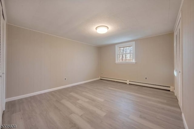 interior space featuring a baseboard radiator and light hardwood / wood-style flooring