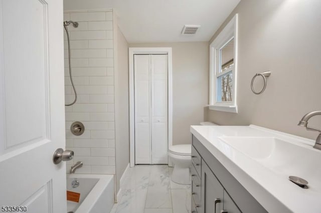 full bathroom featuring tiled shower / bath, vanity, and toilet