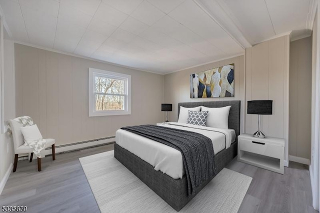 bedroom featuring a baseboard radiator, wood-type flooring, and ornamental molding