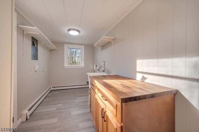 kitchen featuring a baseboard heating unit, butcher block counters, sink, and light wood-type flooring