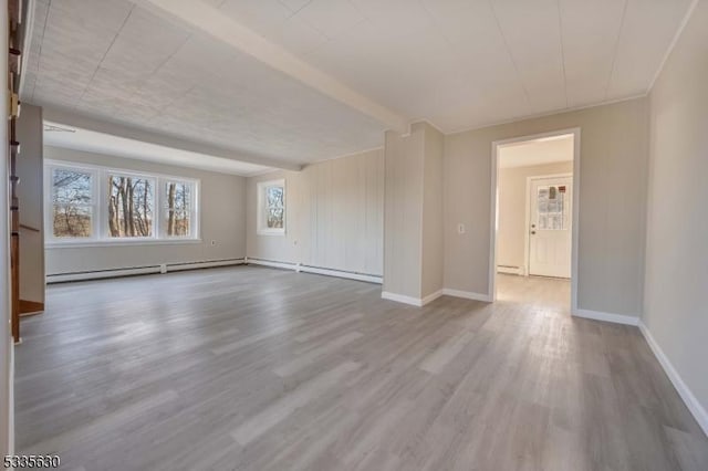 spare room with a baseboard radiator and light hardwood / wood-style flooring