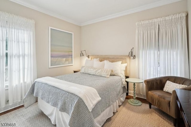 bedroom with multiple windows, crown molding, and light wood-type flooring