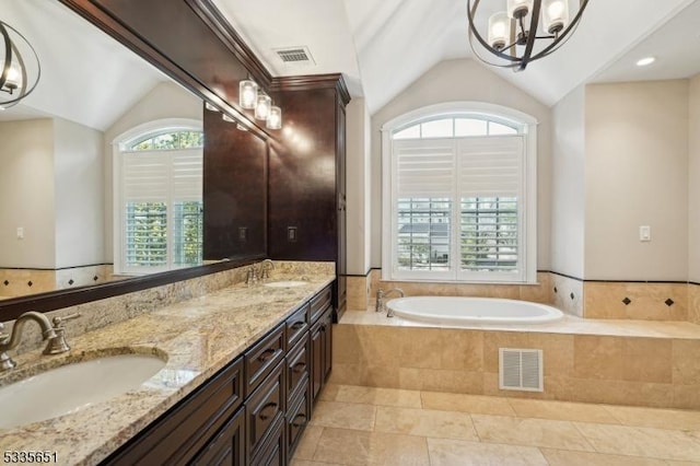 bathroom featuring lofted ceiling, vanity, tile patterned floors, and tiled bath